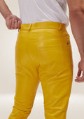 Slim fit men’s yellow leather pants with side pockets, styled with colorful sneakers for a vibrant look